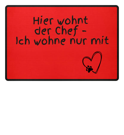 Detailaufnahme der Schrift auf der Fußmatte „Hier wohnt der Chef“ - rot