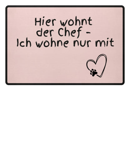 Humorvolle Fußmatte für Paare mit dem Spruch „Hier wohnt der Chef – Ich wohne nur mit“ - pink